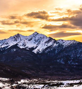 Golden sunset over a majestic snow-capped mountain range.