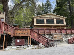 Entrance to rustic North Cascades lodging at Stehekin, Lake Chelan, with welcome sign, lodge, and nearby visitor amenities.