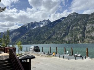 Ferry docked at Lake Chelan with stunning mountain views near North Cascades lodging, surrounded by rugged, snow-capped peaks.